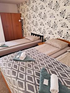密古雷休治7 Levél Panzió, Ultra Central, Self Check-in, Self-Catering的一间卧室设有两张床和鲜花墙