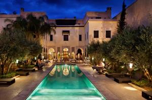 马拉喀什橘园别墅 - 罗莱夏朵酒店的享有带游泳池的大厦外部景色