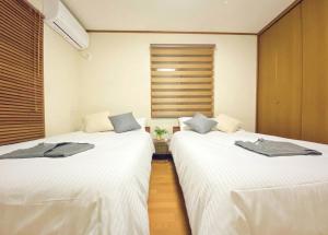 Mongawaさくらや旅館的两张睡床彼此相邻,位于一个房间里