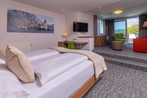 格蒙登Seehotel im Weyer的酒店客房设有一张大床和一台电视。