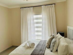 逊邱伦Wanderlust 2-bedroom Apartment的卧室配有带枕头的床铺和窗户。