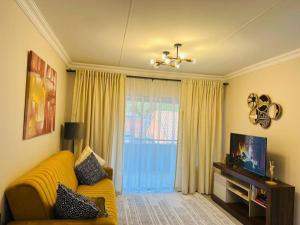 逊邱伦Wanderlust 2-bedroom Apartment的客厅配有黄色沙发和电视