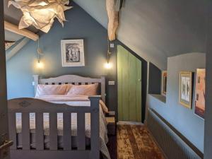 切尔滕纳姆Stylish 3 bed Cotswold cottage with stunning views的一间卧室设有一张床和一个绿门