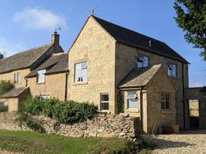 切尔滕纳姆Stylish 3 bed Cotswold cottage with stunning views的一座带石墙的大型砖屋