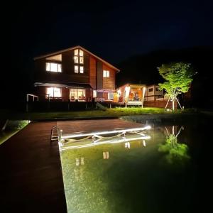 信浓The Lake House 野尻湖的一座晚上设有游泳池的房子
