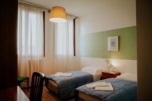 威尼斯卡萨艾卡达米亚旅舍的酒店客房设有两张床和窗户。