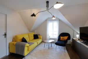 维泰勒Calme, Confort et Propreté的客厅配有黄色沙发和两把椅子
