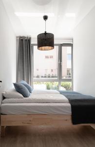 格但斯克Scala Apartamenty by Moderna Profit- Łąkowa 60K的一间卧室设有一张大床和一个窗户。