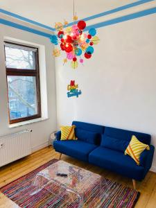 杜伊斯堡SECRET HIDEAWAYS Design Apartment ARTstudio 5 nahe City l Messe l Hbf的客厅配有蓝色的沙发和吊灯。