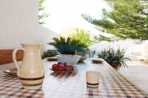 厄尔·波普瑙·德尔·戴尔Llevantada - Casa en Poblenou del Delta con piscina privada y barbacoa的一张桌子,上面有花瓶和一碗水果