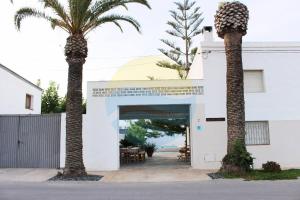 厄尔·波普瑙·德尔·戴尔Llevantada - Casa en Poblenou del Delta con piscina privada y barbacoa的两棵棕榈树,在一座建筑前