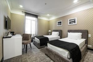 敖德萨Wall Street Maestro的酒店客房,配有两张床和椅子
