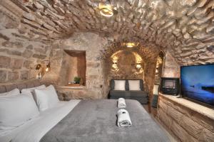 萨法德סוויטת גן עדן - Gan Eden Suite的卧室配有一张石墙内的大床