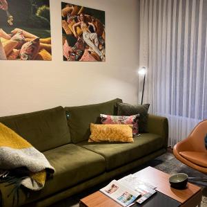巴登韦勒希罗斯伯格酒店的客厅配有绿色沙发和桌子