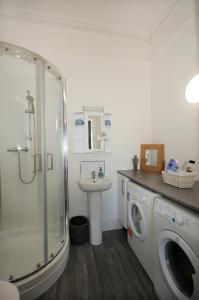 佩恩顿Loveliest Homes Paignton - Wavecrest Apartments - mixed sizes - parking的一间带洗衣机和水槽的浴室