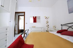 莱乌卡A Casa di Doralucia - Comfort a Santa Maria di Leuca的一间卧室配有黄色的床和红色枕头