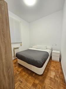 马德里MAD COCO Apartamento Frente al Prado的一间铺有木地板的白色卧室,配有一张床