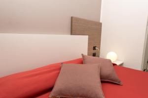 朱利亚诺瓦泽尼特酒店 的一间卧室配有红色的床和两个枕头