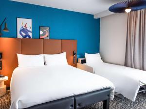 波尔尼谢ibis La Baule Pornichet Plage的蓝色墙壁客房的两张床