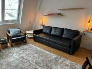 阿斯托恩Apartamento Astun的客厅配有黑色沙发和椅子
