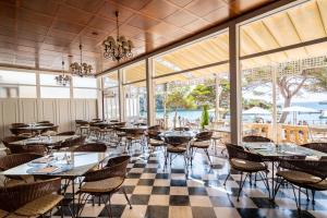 克里斯托港THB费利浦成人酒店的餐厅设有桌椅和窗户。