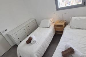 Bayit Weganוגאס的一间卧室配有两张床和一个带毛巾的梳妆台。