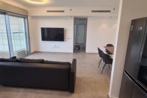 Bayit Weganוגאס的带沙发、电视和桌子的客厅