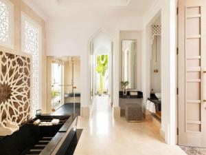 麦纳麦Raffles Al Areen Palace Bahrain的客厅设有白色的墙壁和黑色的沙发。