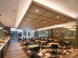 墨尔本Mercure Melbourne Southbank的大楼内带桌椅的餐厅