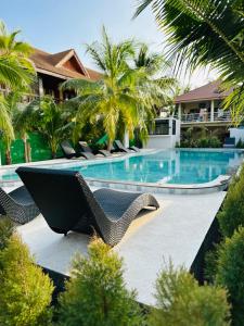 哈林海滩Family House Resort, Haad Rin的一个带椅子和树木的游泳池的度假酒店