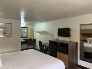 Cross LanesMotel 6 Cross Lanes, WV Goff Mountain Rd的酒店客房配有一张床和一张书桌及一台电视