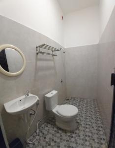 卢武克Dehills Hotel Luwuk的一间带卫生间、水槽和镜子的浴室