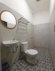 卢武克Dehills Hotel Luwuk的一间带水槽、卫生间和镜子的浴室