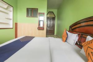 斯利那加SPOT ON Valley Meadow的一间卧室设有床铺和绿色的墙壁