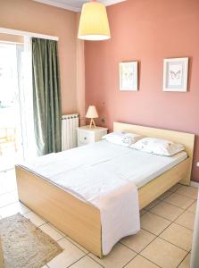 拉夫里翁Spacious & Bright flat with balcony的卧室配有一张带粉红色墙壁的大床