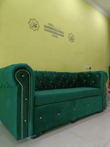 樟仑IRDINA HOMESTAY - Changlun, Kedah的墙上贴着标签的绿色沙发
