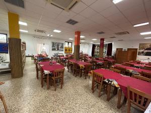 卡塔尼亚Beteyà Hostel Don Bosco的用餐室配有红色桌子和木椅