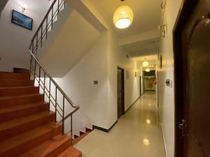 蓬蒂切里La Paradise Residency的走廊上设有楼梯和灯