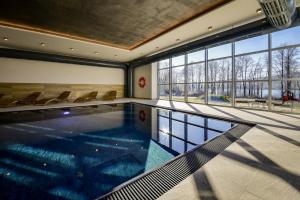 霍尼普拉纳Resort Orsino的一座带椅子和窗户的建筑中的游泳池