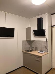 科特卡Budget apartment in Kotka # 16的一个带水槽的厨房和墙上的电视