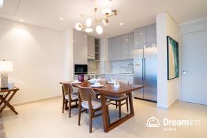 富查伊拉Dream Inn - Address Beach Residence - Luxury Apartments的厨房以及带木桌和椅子的用餐室。