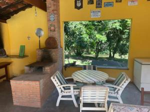 布拉干萨-保利斯塔Sítio Ipecamirim的庭院配有桌椅和壁炉。