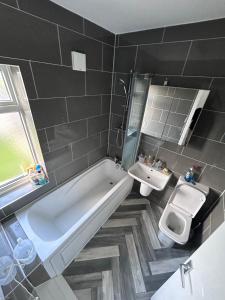SkegbyGlo Stay @ Hibbert Crescent的带浴缸、卫生间和盥洗盆的浴室