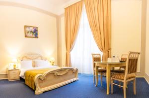 利沃夫乔治酒店的一间卧室配有一张床、一张桌子和一张桌子