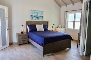 英吉利港The Moxy的一间卧室配有一张带蓝色床单的床和一扇窗户。