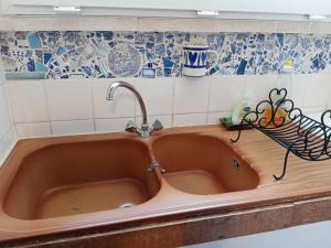 Puy-lʼÉvêqueDomaine de la Borde的厨房里设有铜制水槽,铺有蓝色和白色的瓷砖