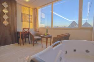 开罗The Muse Pyramids Inn Hotel的带浴缸和桌椅的浴室