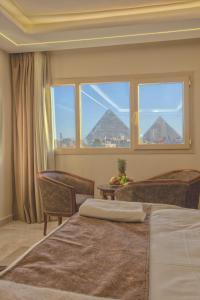 开罗The Muse Pyramids Inn Hotel的一间卧室设有两张床和大窗户
