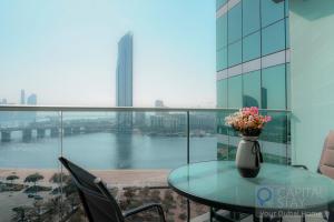 迪拜Capital Stay - 2 Bed Apartment in Dubai Festival City的阳台上的玻璃桌,花瓶