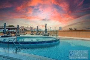 迪拜Capital Stay - 2 Bed Apartment in Dubai Festival City的一座享有日落美景的大型游泳池